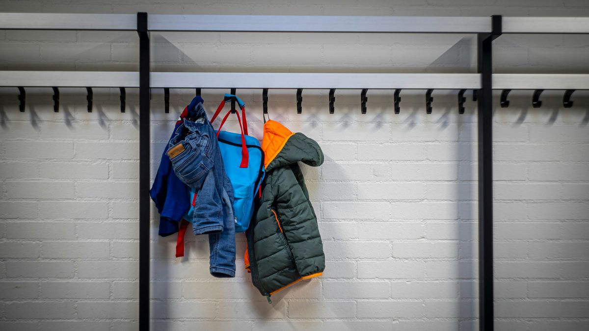 Kinderjasjes, een broekje en een rugzakje aan een kapstok